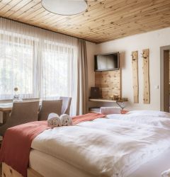Gemütliches Zimmer in Familienpension in Mauterndorf mit Holzdekor und bequemem Doppelbett.