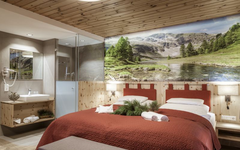 Gemütliches Zimmer in Familienpension mit Holzelementen, Bergwandbild, Doppelbett, Bad im Salzburger Lungau.