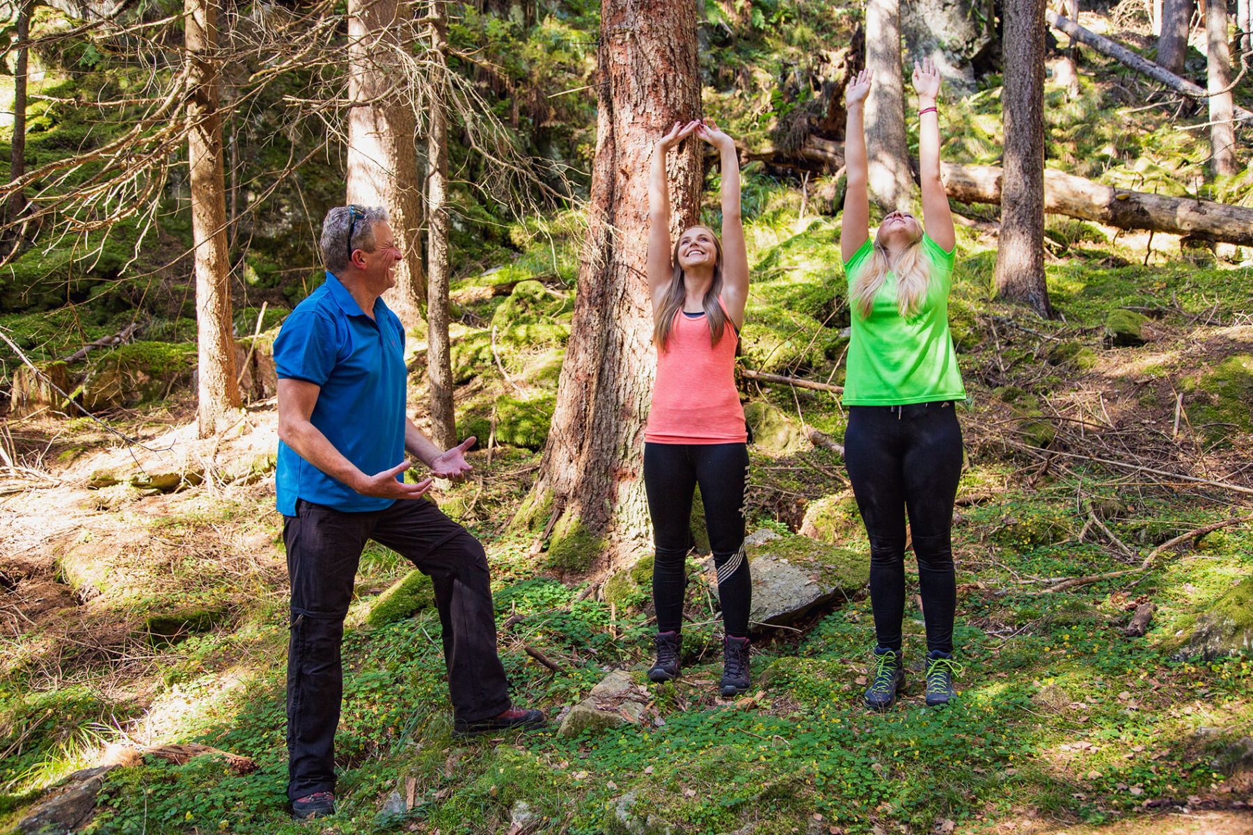 Familie in Sportbekleidung dehnt sich im Wald nahe einer 3-Sterne-Pension im Lungau.