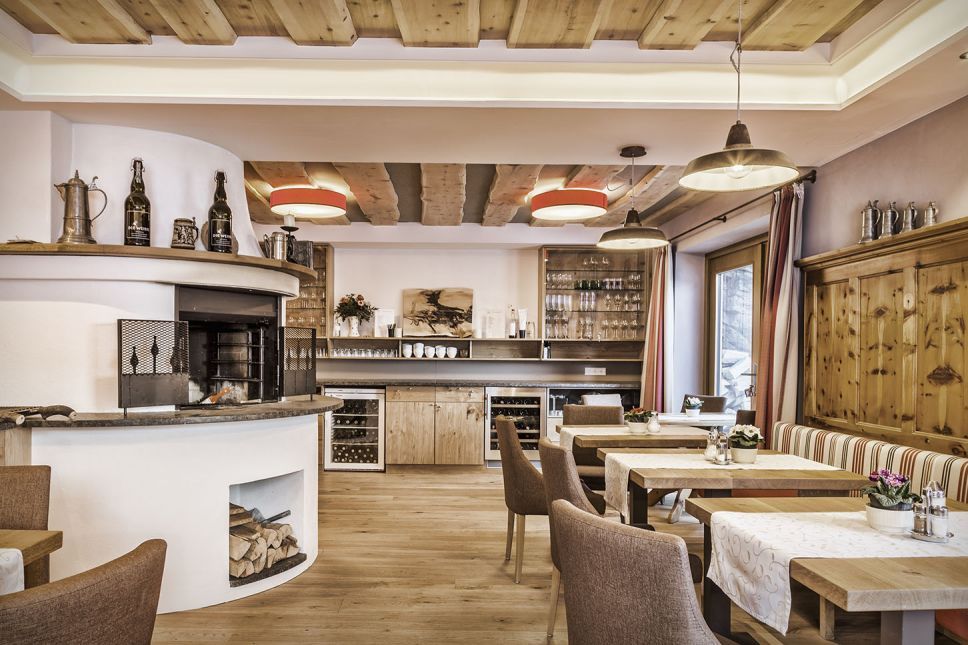 Gemütlicher Speiseraum einer Salzburger Familienpension mit Holzmöbeln und Kamin.