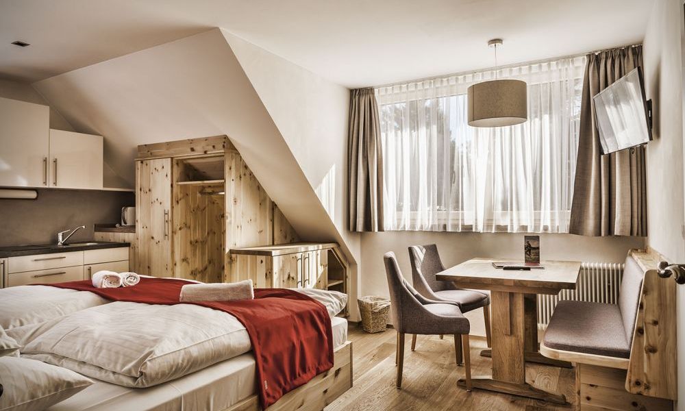 Gemütliches Familienzimmer mit Holzmöbeln, Betten, Kitchenette, Esstisch, in heller Pension im Salzburger Lungau.