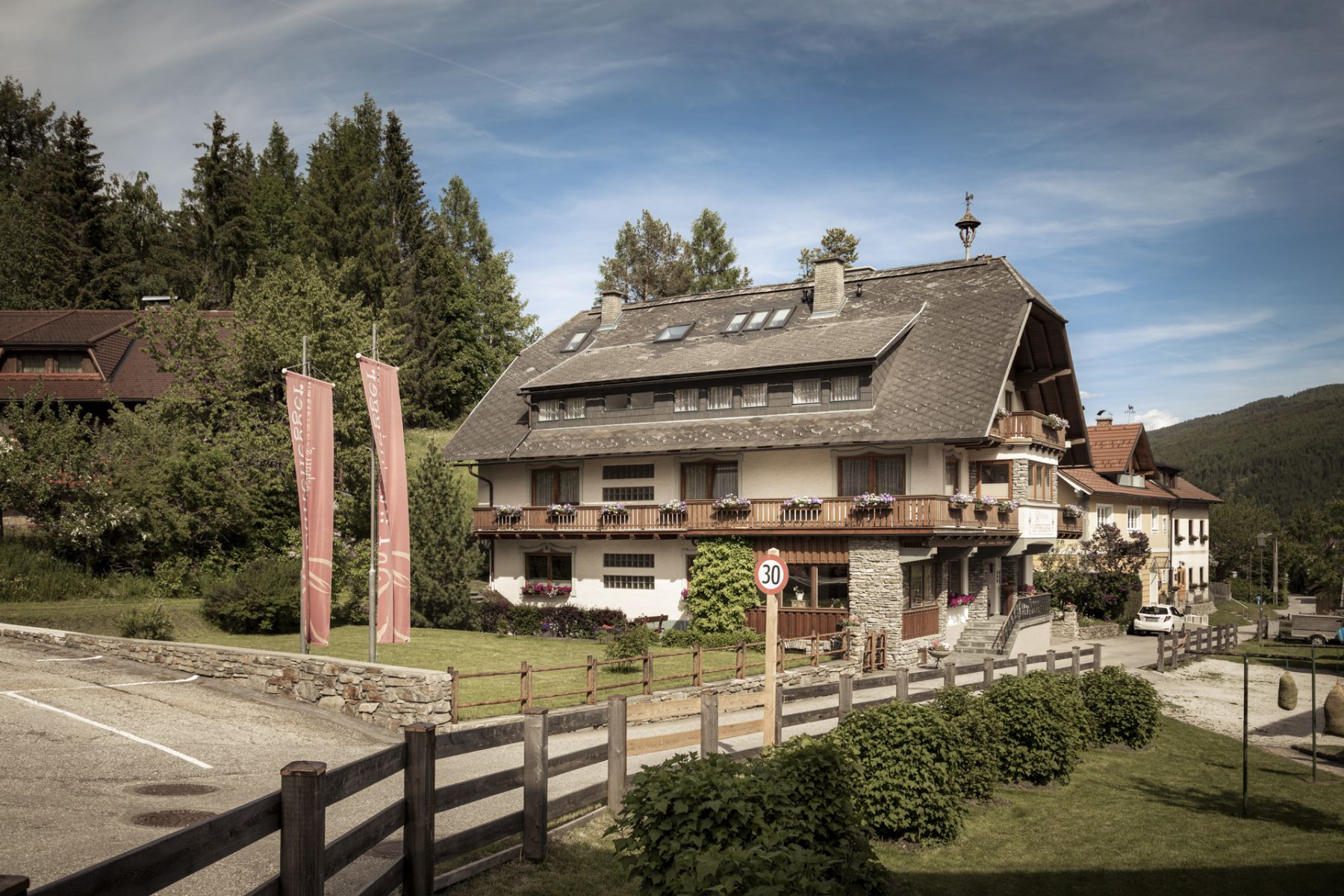 Drei-Sterne-Familienpension in Mauterndorf, Salzburger Lungau, mit Holzbalkonen und grüner Umgebung.
