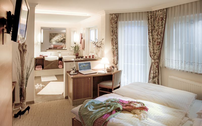 Gemütliches Zimmer in 3-Sterne-Familienpension im Salzburger Lungau, rustikale Einrichtung, Doppelbett, Bergblick.