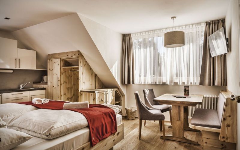 Gemütliches Familienzimmer mit Holzmöbeln, Betten, Kitchenette, Esstisch, in heller Pension im Salzburger Lungau.